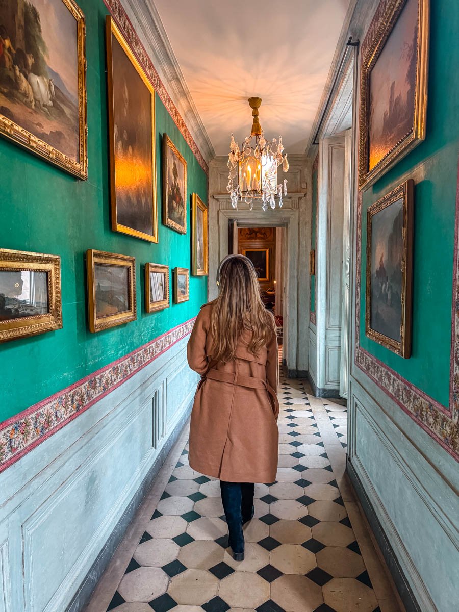 A green hall in Hotel de la Marine with Sam walking down the checkered floor.